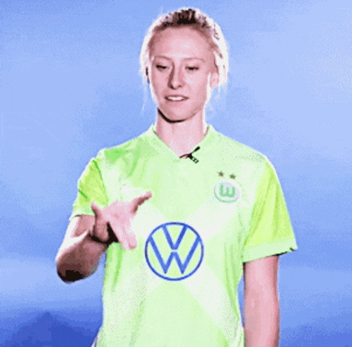 a woman wearing a green shirt with a vw logo on the front