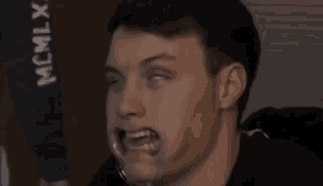 a close up of a man 's face with his eyes closed and his mouth open .