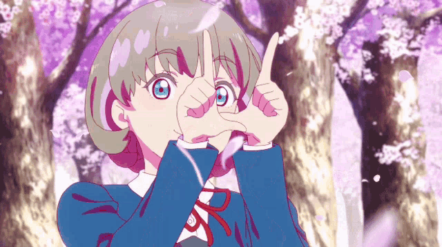 a girl is making a peace sign with her hands in front of a cherry blossom tree