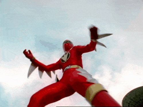 a red power ranger is holding two knives in his hand