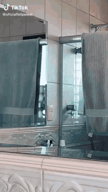 a bathroom with a mirror and a towel hanging on the wall with a tiktok watermark