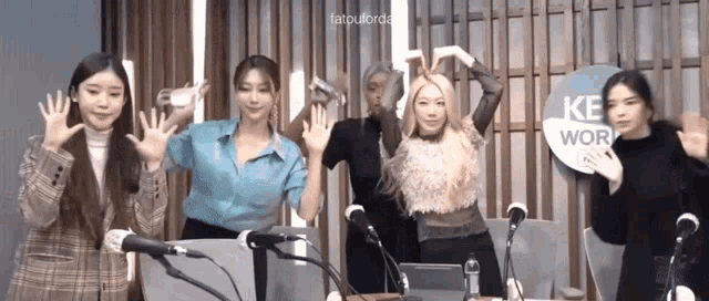 a group of women are standing in front of microphones and a sign that says ke work