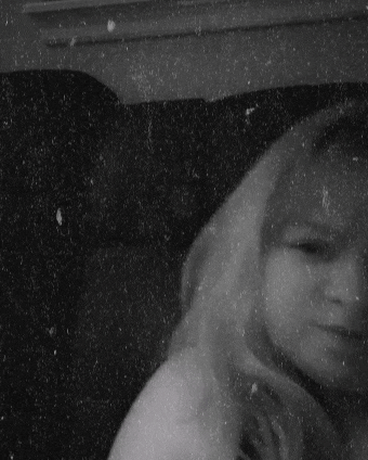 a black and white photo of a woman 's face with a grainy texture