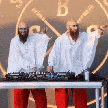 two men in white shirts and red pants are playing music