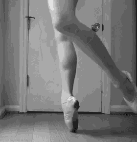 a black and white photo of a ballerina 's legs and feet .