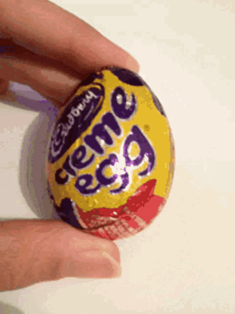someone is holding a cadbury creme egg