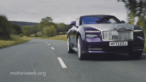 a purple car with the license plate hy73 ezj is driving down a road