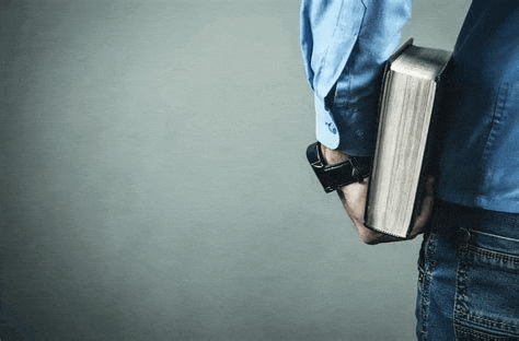 a man is holding a bible in his hands .