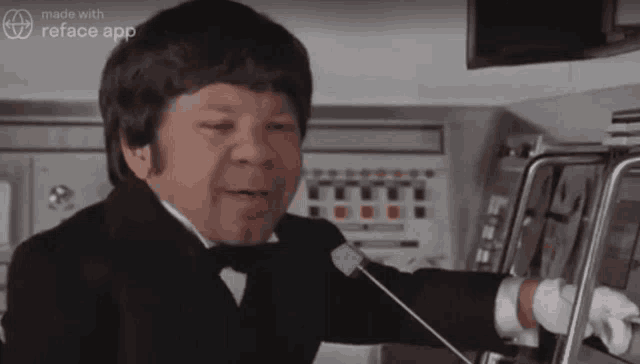 a man in a tuxedo is talking into a microphone with the words made with reface app on the bottom
