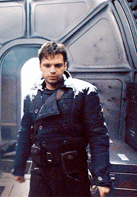 a man in a black coat with snow on his jacket