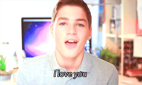 a young man says " i love you " in front of a computer monitor