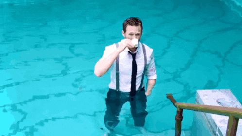 a man in a suit and tie is standing in a swimming pool