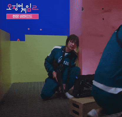 a person kneeling down holding a gun with the number 120 on it