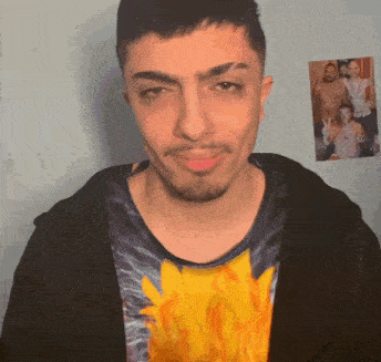 a man with a beard is wearing a t-shirt with flames on it .
