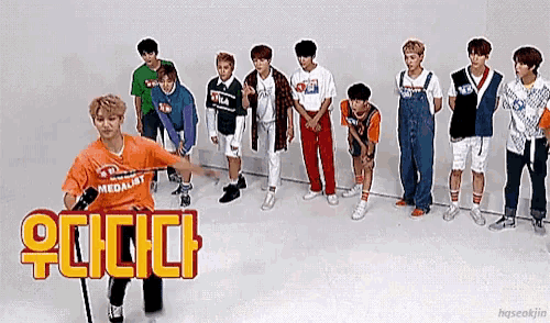 a group of young men are standing in a line and one of them is wearing an orange shirt that says medalist