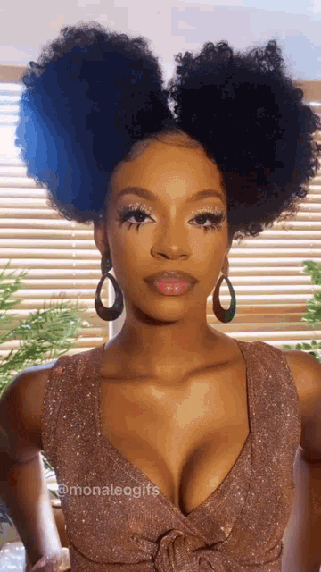 a woman with curly hair and a plunging neckline wears earrings