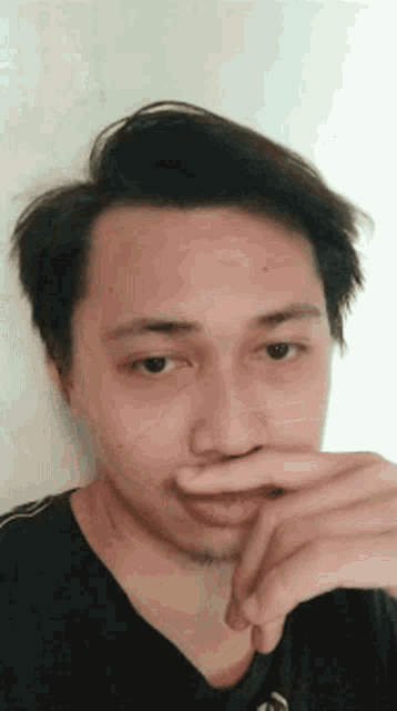 a man is covering his mouth with his hand