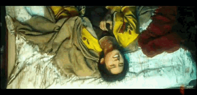 a man in a yellow shirt is laying on a bed
