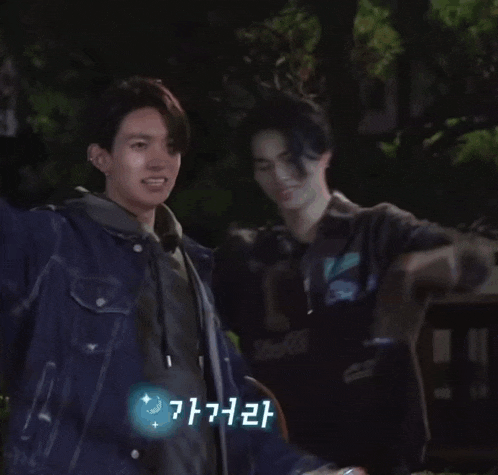 a man in a denim jacket is holding something in his hand in a foreign language