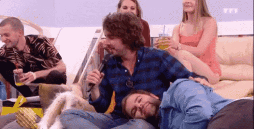 a group of people are sitting on a couch and one of them has a tfi logo on the bottom right