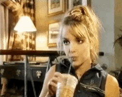 a woman is drinking through a straw from a cup .