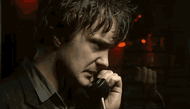 a man is singing into a microphone with his eyes closed .