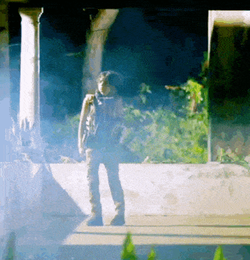 a person standing in a dark room with a smoke coming out of it