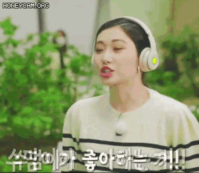 a woman wearing headphones and a striped shirt is talking to someone .