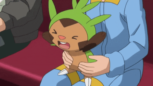 a person is holding a cartoon character with a green hat on