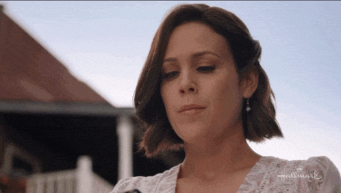a woman wearing a white top with the word hallmark on it