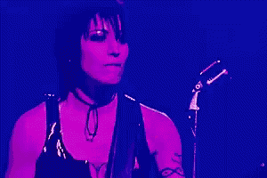 a person is playing a guitar on a stage in a dark room .