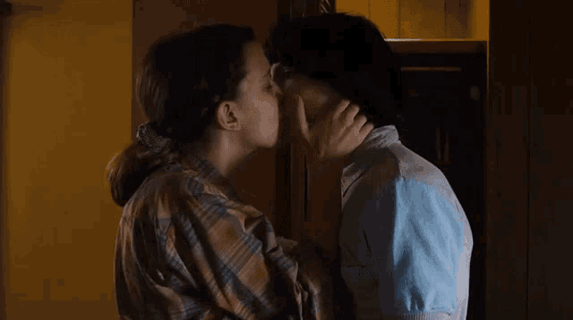 a man and a woman are kissing each other in a dark room .
