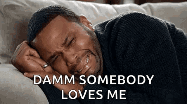 a man is laying on a couch crying and saying damn somebody loves me
