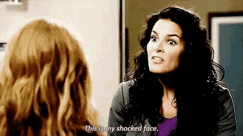 two women are talking to each other and one of them is saying `` this is my shocked face '' .