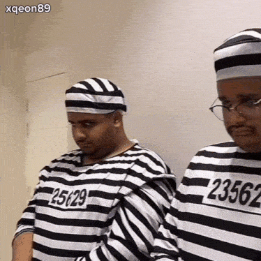 two men in striped prison uniforms with numbers 25129 and 23563