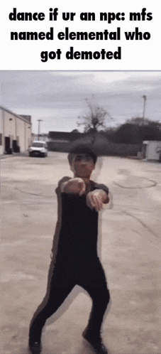 a man is dancing in a parking lot in front of a building .