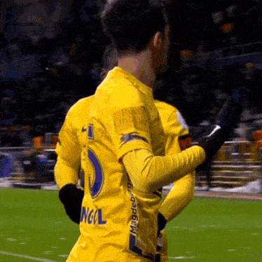 a soccer player wearing a yellow jersey with the number 1 on the back