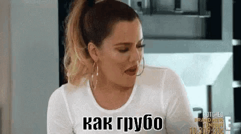 a woman in a white shirt and hoop earrings is talking in russian .