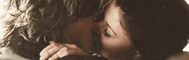a man and a woman are kissing in a close up .