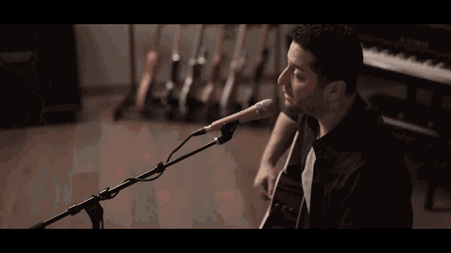 a man singing into a microphone in front of a vox amplifier