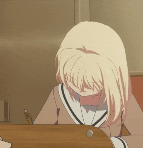 a blonde anime girl is sitting at a desk with a pen in her hand