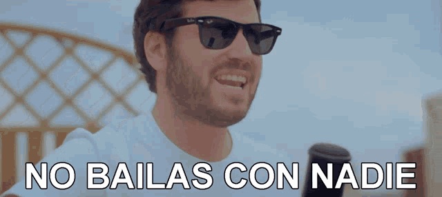 a man wearing sunglasses says no bailas con nadie in white letters