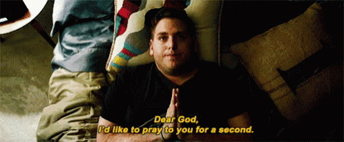 a man is laying on a couch with his hands folded in prayer .