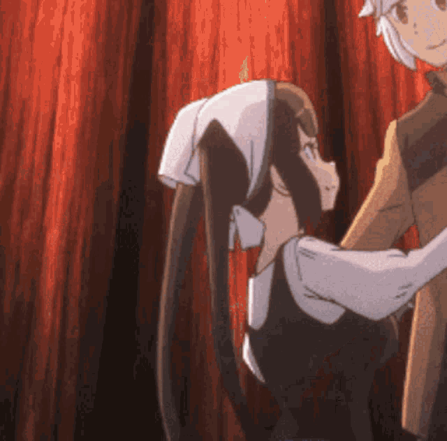a couple of anime characters are hugging each other in front of a red curtain
