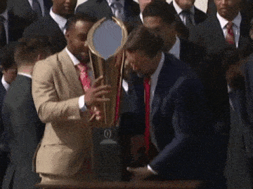 a man in a suit and tie is holding a trophy