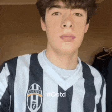 a young man is wearing a black and white striped juventus shirt .
