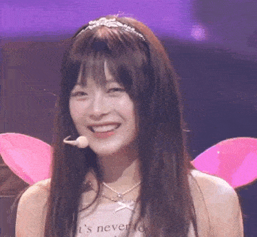a woman wearing a headband and a necklace with the words ' i 's never too to have ' on it
