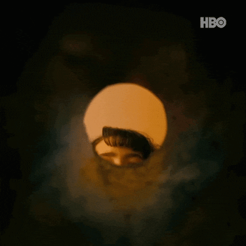 a woman is looking out of a hole in a pipe .