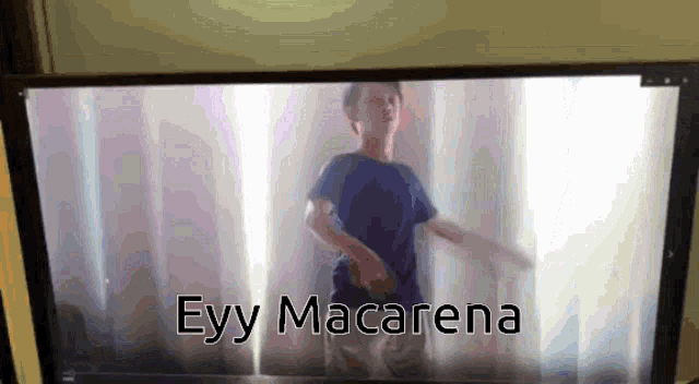 a tv screen shows a boy dancing and the words " eyy macarena " below him