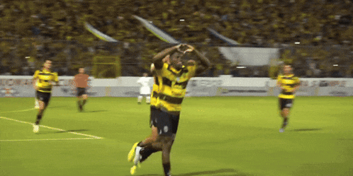 a soccer player wearing a yellow and black jersey with the letter o on it